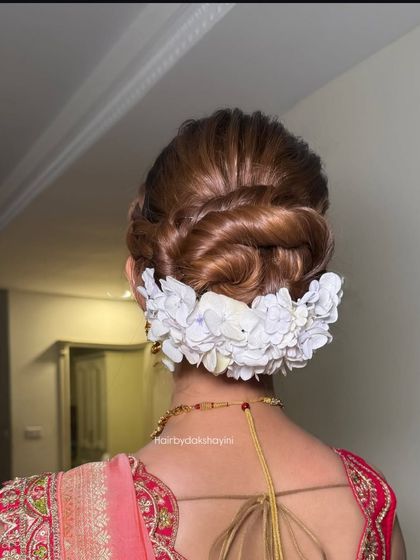A close up of the intricate braided bun with white flowers, showing the texture and detail.