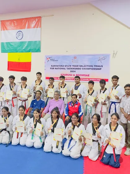 Our team with officials, proudly displaying the Indian and Karnataka flags. We are honored to represent our state and country.