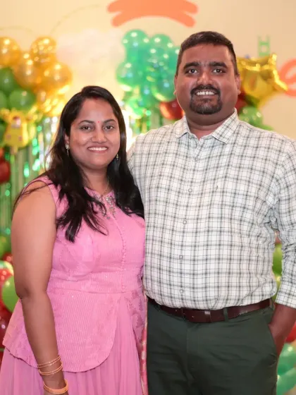 A happy couple posing at a party. We love seeing parents relax and enjoy the celebration.