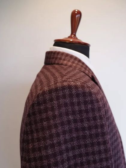 The rich color and classic pattern make this coat a versatile choice for both formal events and smart-casual meetings.