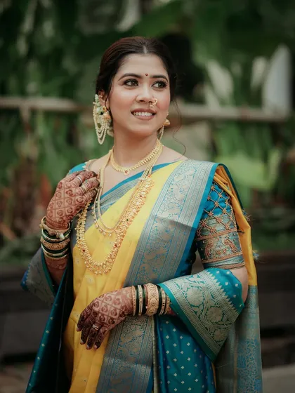 A three-quarter portrait showing the intricate details of the bride's saree and jewelry.