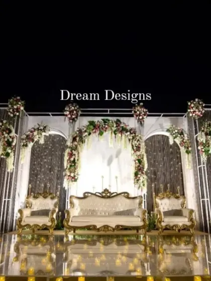 A closer view of the magnificent reception stage. The design features a series of white arches, floral arrangements, and crystal curtains, all reflecting beautifully on the polished golden floor.