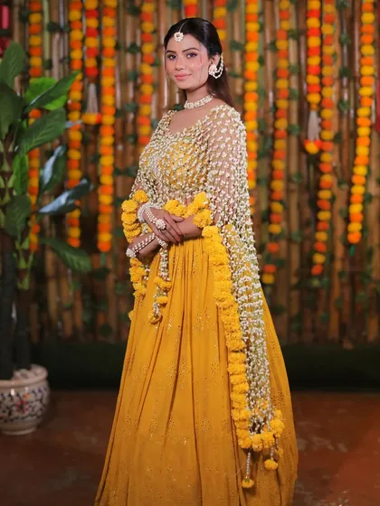 Inspired by celebrity trends, this Haldi look is fresh, vibrant, and unforgettable. We paired glowing skin with a stunning floral dupatta to create a modern yet traditional feel for this joyous occasion.