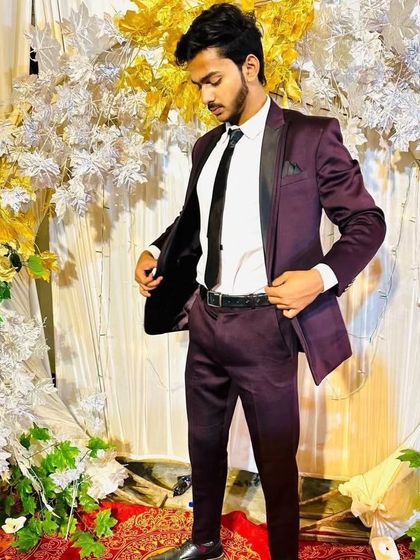 A client styled in a sleek, modern wine colored suit with a satin lapel. This demonstrates how a bold color can be both elegant and perfect for a party.