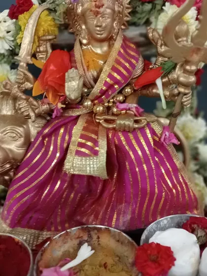 An idol of Durga Maa prepared for worship, adorned with flowers and offerings. I provide guidance on performing Devi Puja to invoke her divine energy for protection, courage, and the removal of negativity.