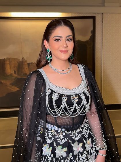 The final look, glammed to perfection. The clean makeup and radiant skin complement her intricate black and silver outfit beautifully.