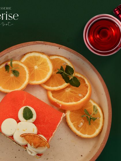 A slice of the Citrus Chill, plated with fresh orange slices to highlight its key ingredient. It's a fresh, fruity, and fabulous dessert.