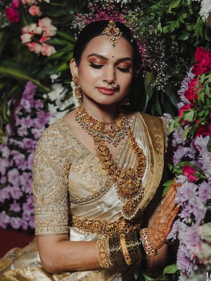 A close-up of a bride, showing the detailed embroidery on her blouse and her elaborate temple jewelry. This is a perfect example of a classic South Indian bridal look.