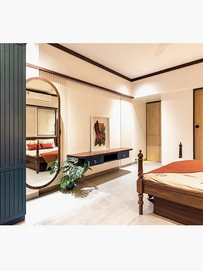 A large, elegantly framed floor mirror reflects the bed and makes the room feel larger and brighter. It serves as both a functional dressing mirror and a beautiful decorative element.