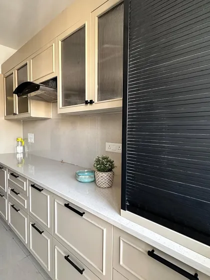 This view highlights the practical inclusion of a rolling shutter unit for appliances, keeping the countertop clutter-free.