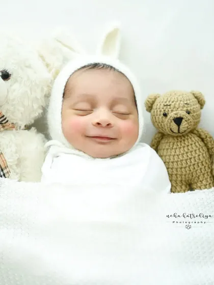 That heart-melting newborn smile. I live for these moments of pure, sleepy joy. This little one is wrapped cozily in a white bunny bonnet, ready for a sweet dream.