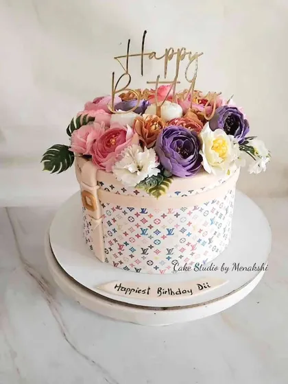 For a very special sister, I designed this elegant Louis Vuitton inspired hat box cake. It's topped with a beautiful bouquet of handmade sugar flowers, combining luxury fashion with delicate artistry.