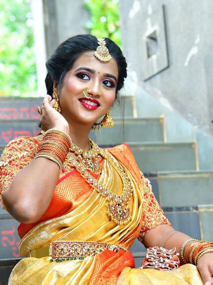 A model showcasing a beautiful Kemp jewellery set. The vibrant red and green stones in the choker and haram create a striking look, perfect for a traditional bride.