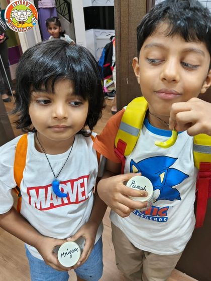 Teamwork makes the dream work! These two buddies are showing off their finished dino necklaces, each one a unique creation from our hands-on art and science session.