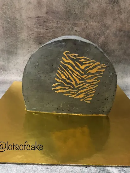 I love experimenting with modern cake trends like this top forward design. This red velvet cake features a concrete-effect buttercream and a striking gold tiger-stripe stencil, creating a bold and artistic statement piece.