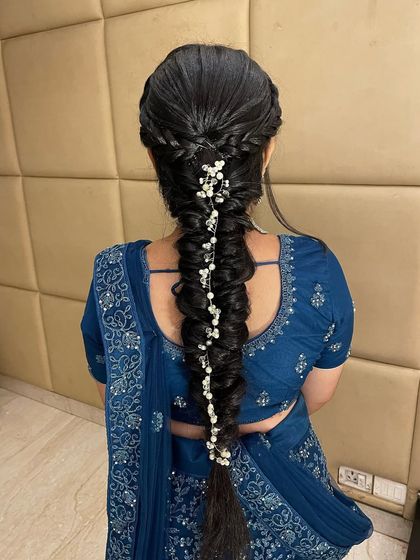 An intricate and modern fishtail braid, decorated with delicate pearl accessories. This hairstyle is perfect for a sangeet or reception lehenga.