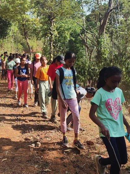 Young adventurers confidently lead the way on a trekking path at our Barapole nature camp.