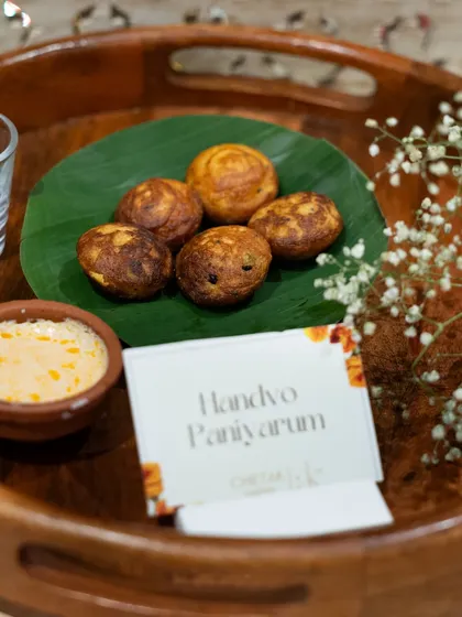 A taste of Gujarat with our Handvo Paniyaram. These savoury, pan-fried cakes are soft on the inside and crisp on the outside, served with a complementary chutney in an earthen bowl.