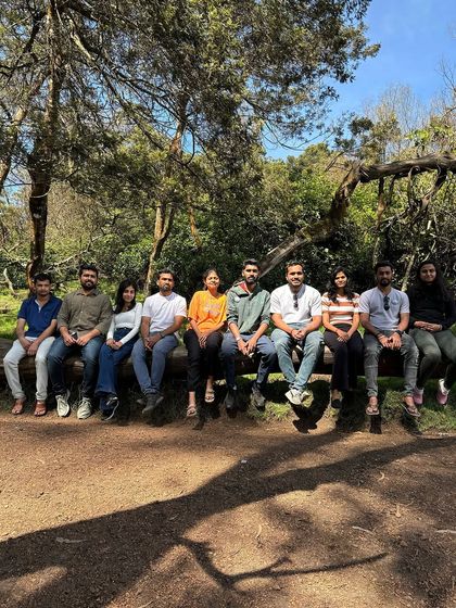 A group sitting on a log in a sunny patch of the Kodaikanal forest.