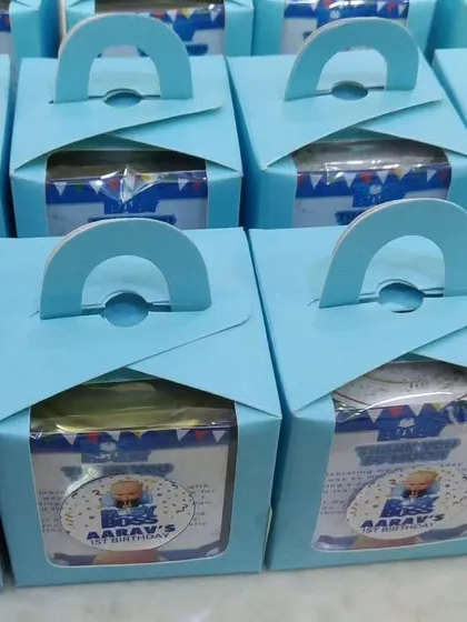 These 'Boss Baby' themed return gift boxes are a great budget-friendly option. They come with a handle for easy carrying and a window to show the treats inside, all personalized for the event.