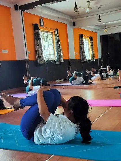 A group of students in Pavanmuktasana (Wind-Relieving Pose), which is excellent for digestion.