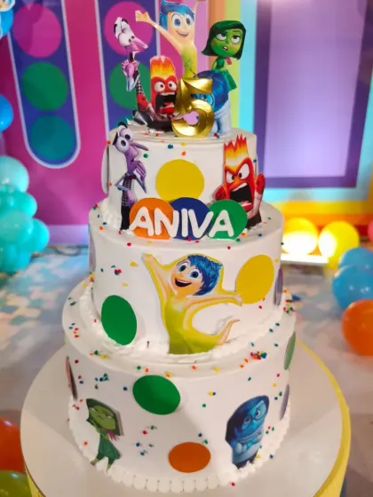 An exciting three-tier "Inside Out" themed cake, showcasing all the emotions from the movie with colorful polka dots and character toppers.