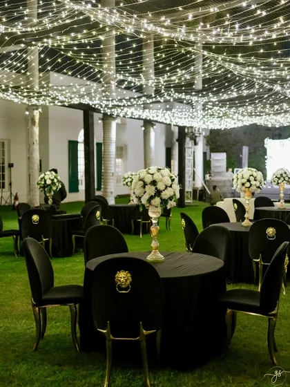 Elegant black and white themed guest seating under the starry fairy light canopy, perfect for a glamorous outdoor Sangeet.