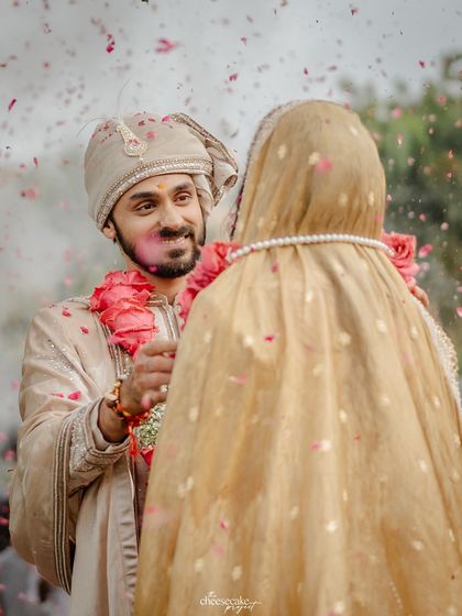 A close-up of the groom's loving expression as he looks at his bride during the garland exchange.