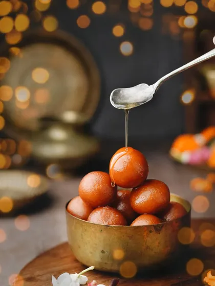 Who doesn't love baby gulab jamuns? This festive shot uses beautiful bokeh from Diwali lights to frame the bowl of sweets, with a syrup drizzle adding a touch of action.