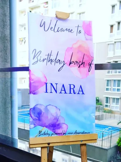 A personalized welcome board for Inara's birthday party, set against the backdrop of the venue's pool, giving guests a glimpse of the fun to come.