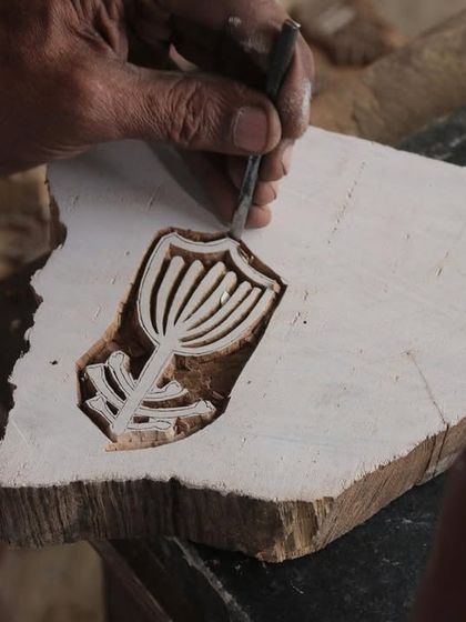 A close-up of a master carver's hands bringing a floral design to life on a teak block. This particular block was created for a collaborative workshop with the Fabric Workshop Museum in Philadelphia.