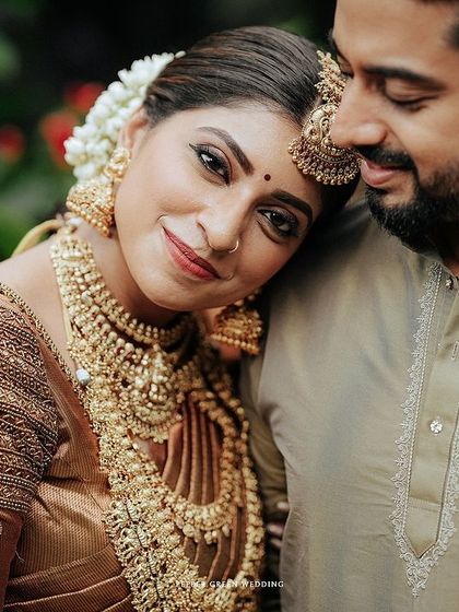 A tender close-up of Sradha and Vinay. The intricate gold jewelry and the emotion in her eyes tell a story of love and tradition.