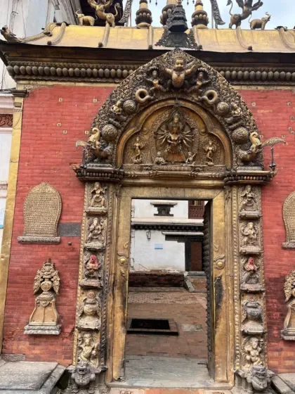 An ornate golden gate, the entrance to a temple courtyard in Bhaktapur. It stands as a testament to the incredible skill of Newar artisans.