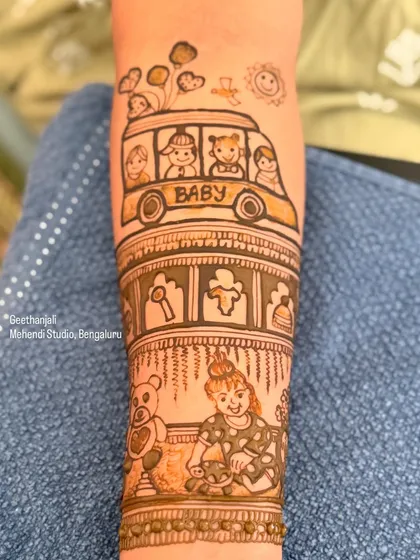 A close up of a custom baby shower mehendi. This design features a 'baby bus', a teddy bear, and a little girl playing, telling a sweet story of childhood.