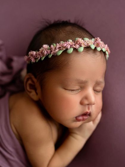 A close-up on her beautiful face. The floral headband adds the perfect finishing touch.