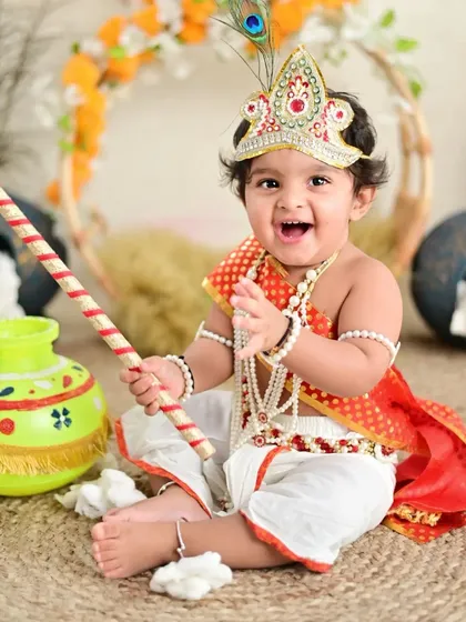 The joy on this little one's face says it all. Our themed shoots, like this popular Little Krishna setup, are all about playful imagination and creating truly unique memories.