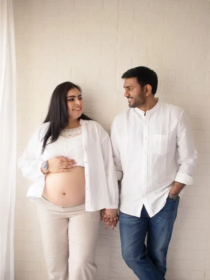 A simple, candid portrait of a couple holding hands. This shows the beauty of a relaxed, lifestyle maternity session, focusing on your natural connection in a comfortable setting.