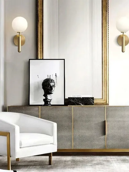 I love using wall lights to create symmetry and frame key features. Here, a pair of my modern globe sconces in a brushed brass finish flank a statement mirror, adding a layer of sophisticated, ambient light to the console area.