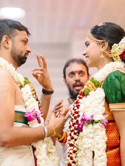 A candid moment of conversation and smiles between the bride and groom during their Tamil wedding ceremony.