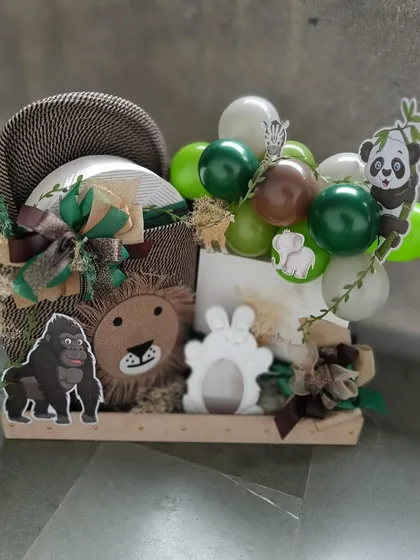A creative jungle-themed gift arrangement featuring a mini balloon arch and adorable animal figures. This hamper is a playful and imaginative way to welcome a new baby.