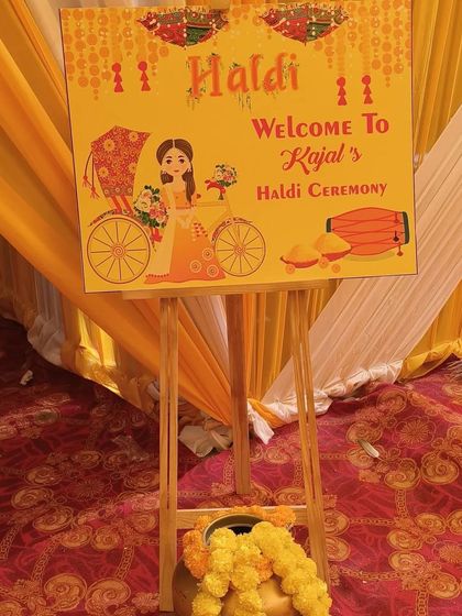 A personalized welcome board is a great way to greet guests. This one, designed for a Haldi ceremony, features a cute caricature and event details, setting a fun tone from the start.