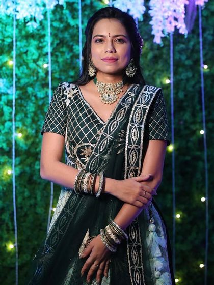 A beautiful portrait of the client in her dark green rental lehenga, looking poised and ready for the celebration.
