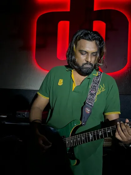 Another look at our guitarist, deep in concentration. He is a virtuoso who takes the stage by storm with every strum.