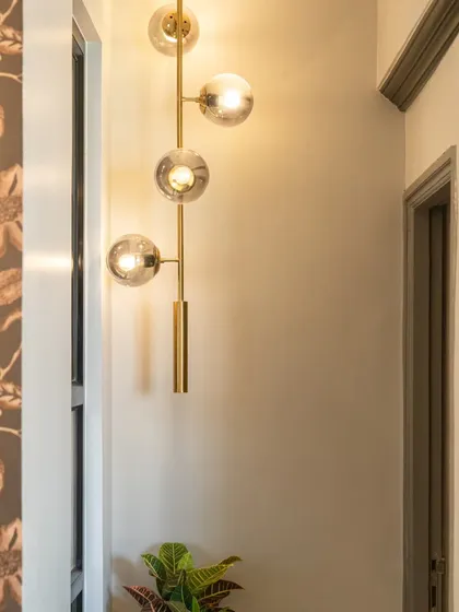 A modern brass and glass globe pendant light adds a touch of elegance to this corridor. We use decorative lighting to transform transitional spaces into beautiful design moments.