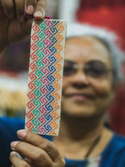 Holding a finished piece is a moment of pure joy. This colorful hand-embroidered bookmark, showcasing a geometric Kasuti pattern, is an example of how even small, everyday items can be transformed into personal works of art.