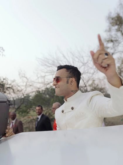 The groom making a stylish and confident entrance. This candid shot captures his personality and the excitement of the baraat as he arrives for his wedding.