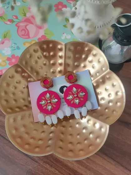 This view of the pink hand-painted earrings showcases their vibrant colour and the delicate white bead drops.