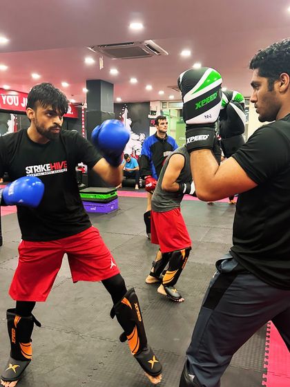 Two students engage in a controlled sparring drill, focusing on blocking and counter-punching. This type of training is crucial for applying techniques in a real-time scenario.