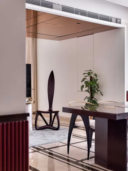 This perspective shows how the home office is cleverly partitioned from the rest of the private areas, with the sculptural chair visible in the reflection of the glossy floor.
