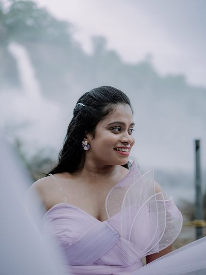 A beautiful portrait of the bride-to-be against a misty waterfall backdrop. The soft lilac color of the gown contrasts wonderfully with the natural scenery.